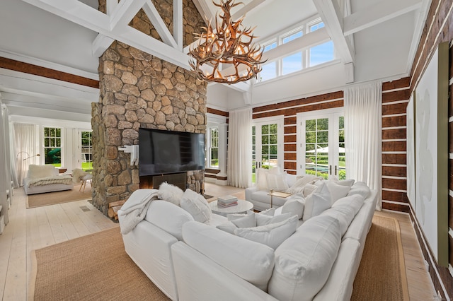 living room featuring a healthy amount of sunlight, a stone fireplace, and light hardwood / wood-style flooring