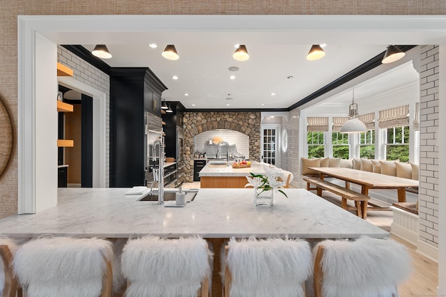 9 Cowdray Park Dr, Greenwich, CT 06831 - kitchen featuring a sink, dark cabinets, crown molding, a fireplace, and light wood finished floors