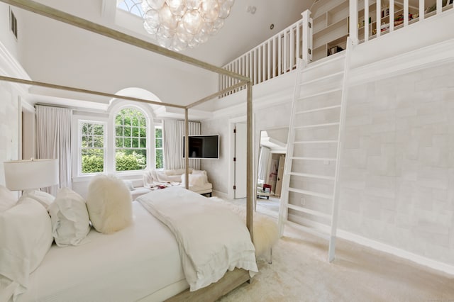 bedroom with a high ceiling, carpet flooring, and an inviting chandelier