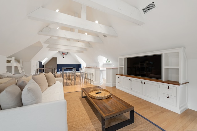 living room with light hardwood / wood-style flooring and vaulted ceiling with beams