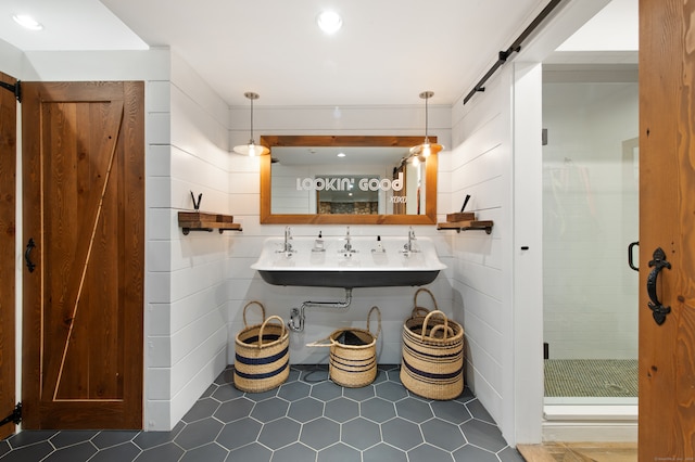 bathroom featuring tile walls, an enclosed shower, and sink