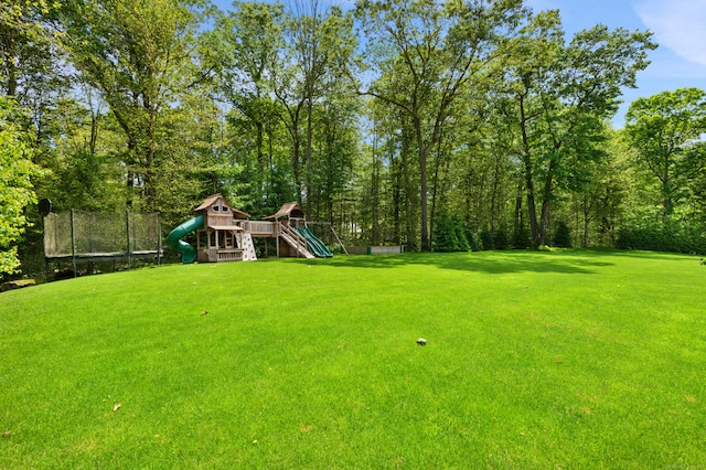 view of yard with a playground and a trampoline