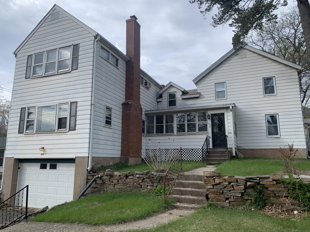 104 Union St, Vernon, CT 06066 - view of front of home featuring a chimney, an attached garage, and entry steps