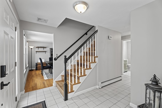 stairway featuring tile patterned flooring and a baseboard heating unit