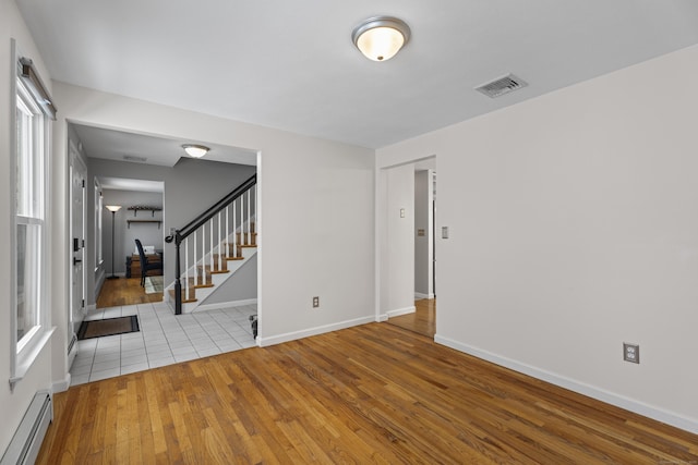 unfurnished room with a baseboard radiator and light hardwood / wood-style floors