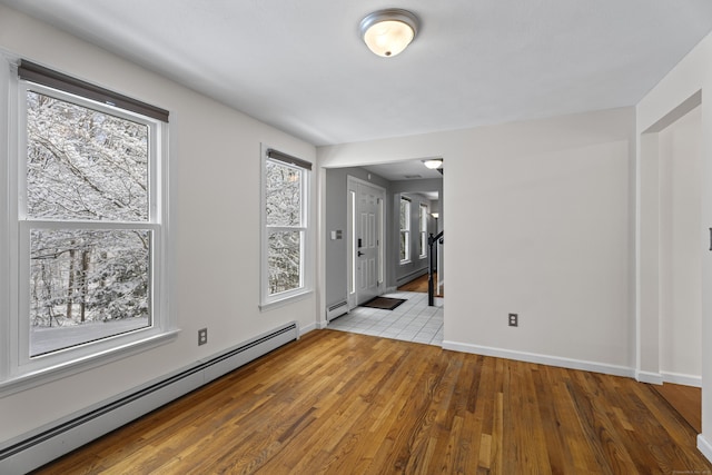 empty room with a baseboard heating unit and light wood-type flooring