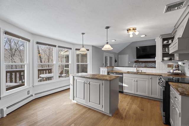 kitchen with a baseboard radiator, sink, hanging light fixtures, stainless steel dishwasher, and black range with electric cooktop