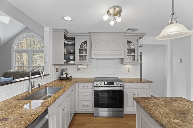 kitchen featuring sink, decorative light fixtures, appliances with stainless steel finishes, custom range hood, and white cabinets