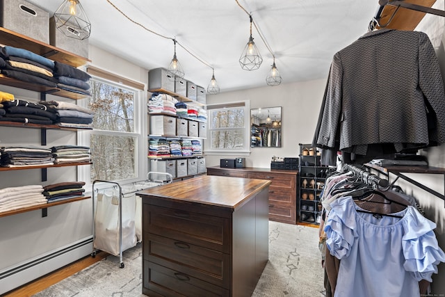 spacious closet featuring baseboard heating and light hardwood / wood-style floors