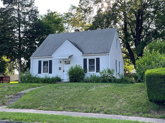 23 Nassau Cir E, Hartford, CT 06118 - new england style home with a chimney, a front lawn, and a shingled roof