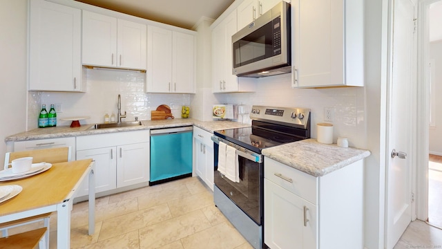 23 Nassau Cir E, Hartford, CT 06118 - kitchen with appliances with stainless steel finishes, backsplash, white cabinetry, and light countertops