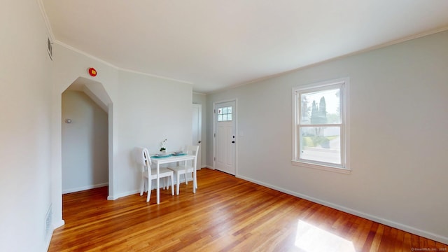 23 Nassau Cir E, Hartford, CT 06118 - dining area featuring light wood-style floors, ornamental molding, and arched walkways