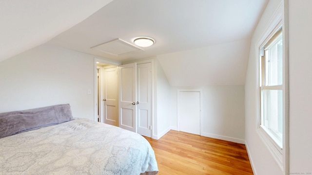 23 Nassau Cir E, Hartford, CT 06118 - bedroom with attic access, light wood finished floors, vaulted ceiling, and multiple windows