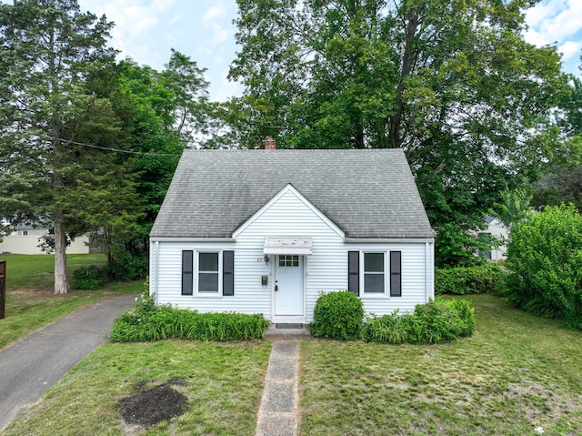 23 Nassau Cir E, Hartford, CT 06118 - new england style home with a front yard, a shingled roof, and a chimney