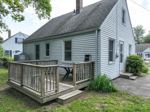 23 Nassau Cir E, Hartford, CT 06118 - back of house featuring a wooden deck, a storage unit, roof with shingles, and a chimney