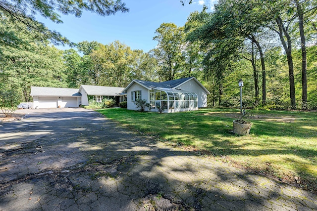 single story home featuring a garage and a front lawn