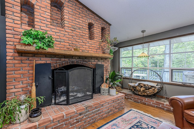 living room with a textured ceiling, a fireplace, light wood-type flooring, and lofted ceiling