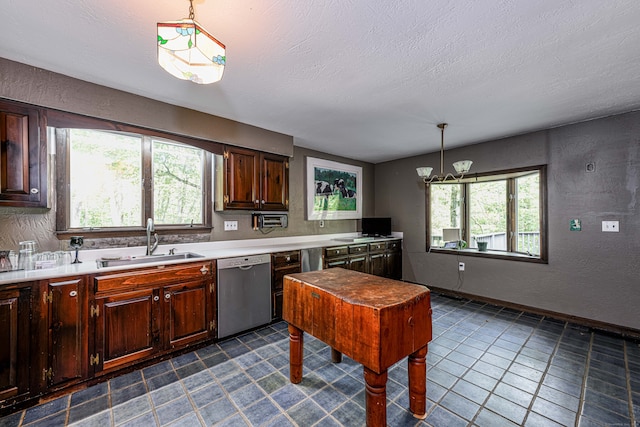 kitchen with a wealth of natural light, decorative light fixtures, sink, and stainless steel dishwasher