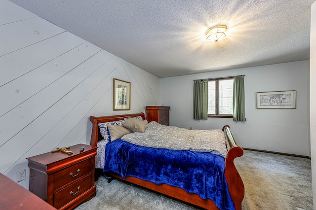 carpeted bedroom with wood walls and a textured ceiling