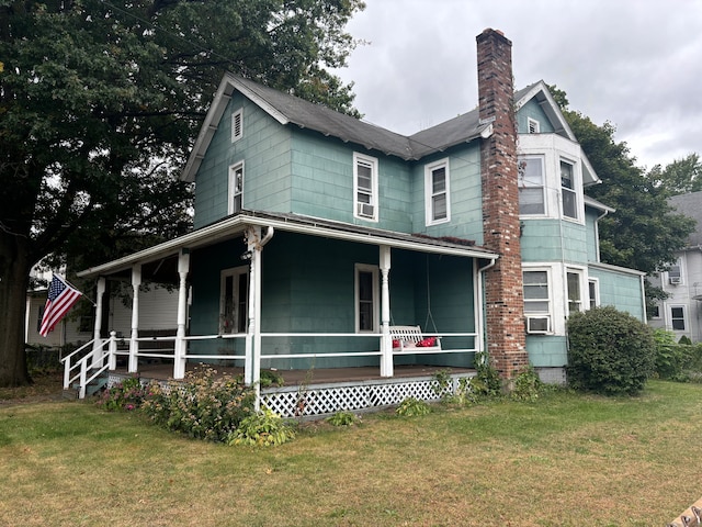 back of property with a yard and a porch