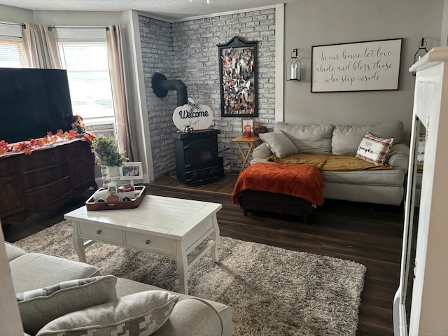 living room featuring a wood stove, a textured ceiling, dark hardwood / wood-style floors, and a fireplace