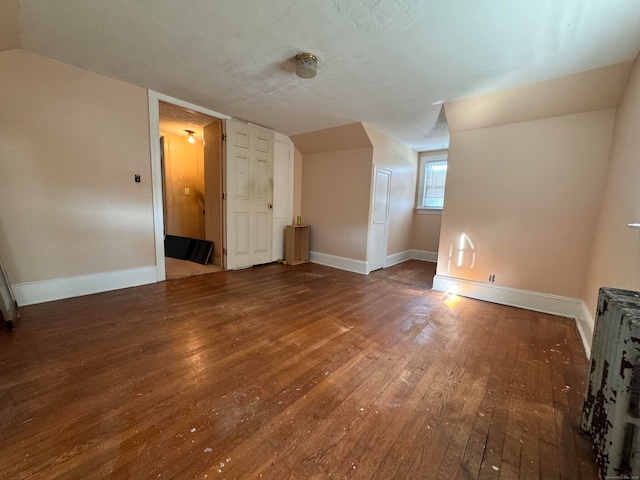 additional living space featuring wood-type flooring and vaulted ceiling