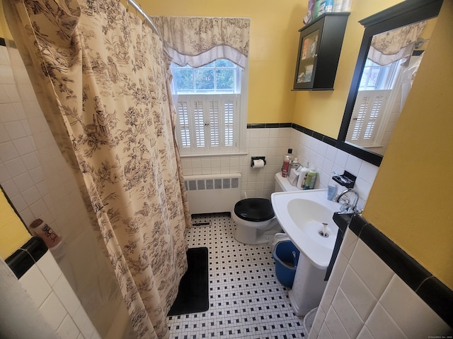 bathroom with radiator, toilet, tile walls, tile patterned flooring, and a shower with shower curtain