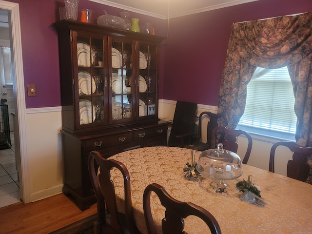 dining area with ornamental molding and hardwood / wood-style flooring