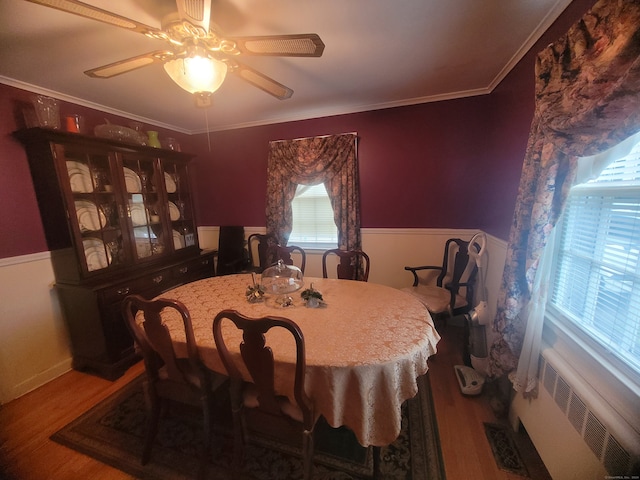 dining area featuring radiator, ceiling fan, hardwood / wood-style flooring, and crown molding