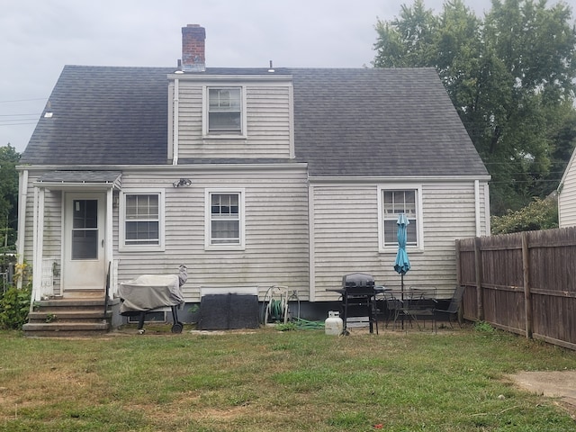 rear view of house featuring a yard