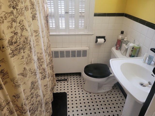 bathroom featuring tile walls, radiator, toilet, and tile patterned floors