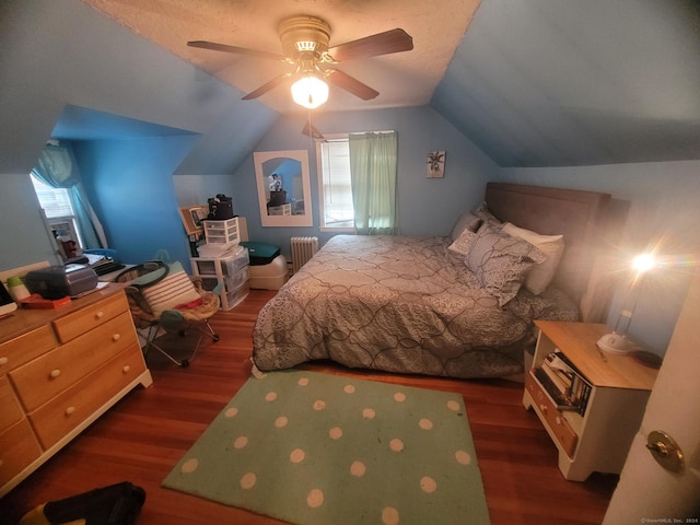 bedroom with radiator, ceiling fan, dark wood-type flooring, and vaulted ceiling