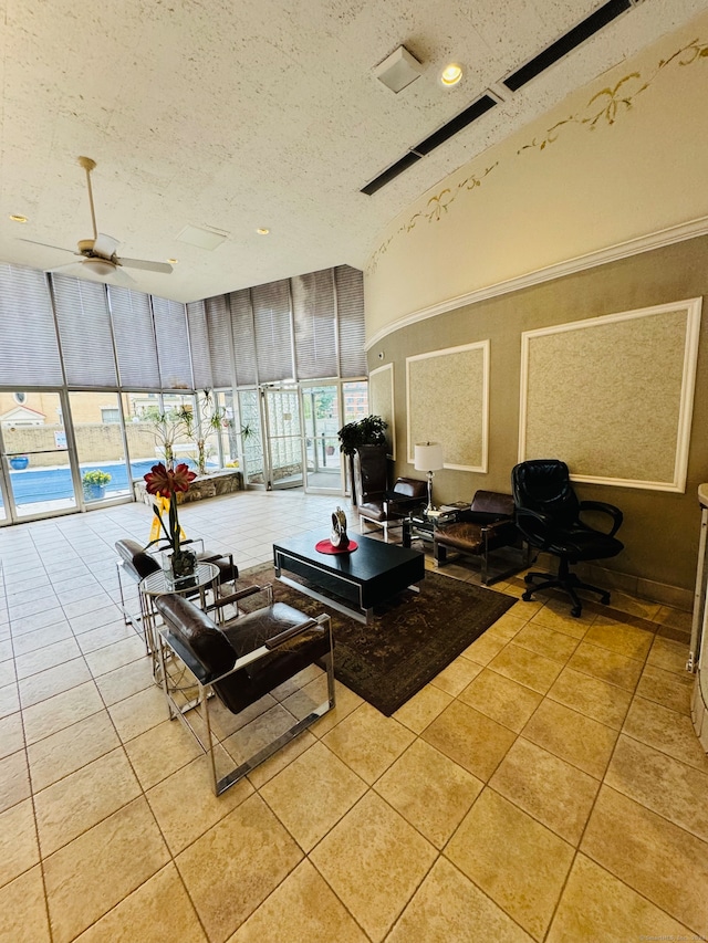 living room with ceiling fan, light tile patterned floors, and a textured ceiling