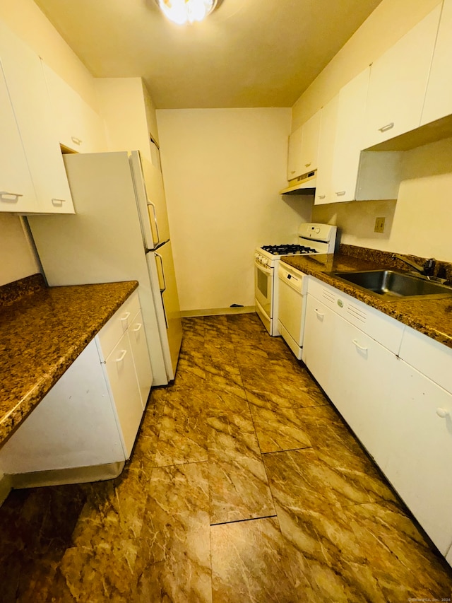 kitchen featuring dark stone counters, white cabinets, white appliances, and sink