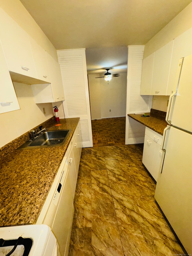 kitchen with white appliances, ceiling fan, white cabinetry, and sink