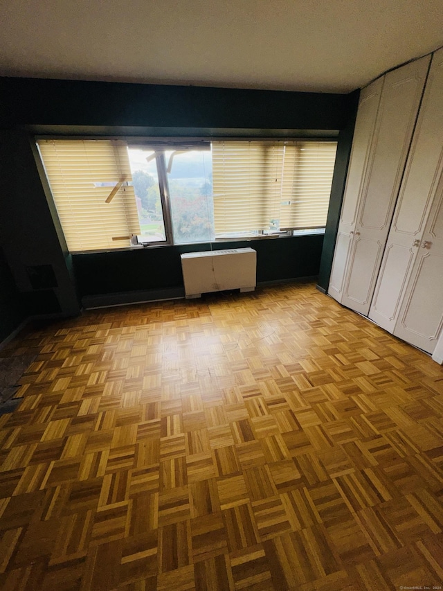 unfurnished bedroom featuring radiator heating unit