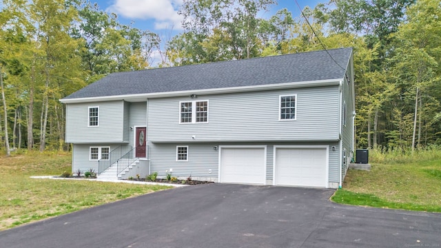 split foyer home featuring a garage and central air condition unit