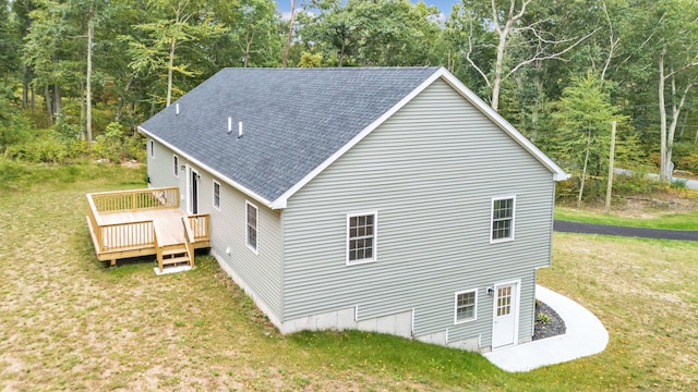 view of home's exterior with a wooden deck and a lawn