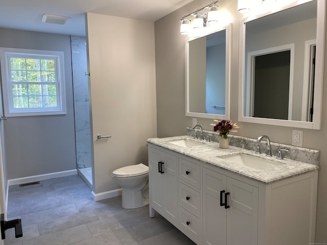 bathroom featuring toilet, vanity, a shower, and tile patterned floors