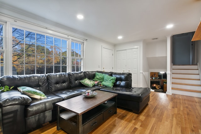 living room with ornamental molding and light wood-type flooring