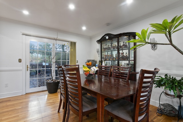 dining space featuring light hardwood / wood-style floors and ornamental molding