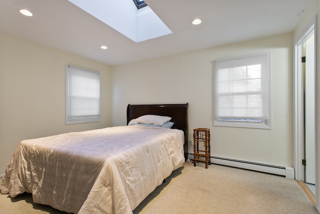 bedroom with a baseboard heating unit, light colored carpet, and a skylight