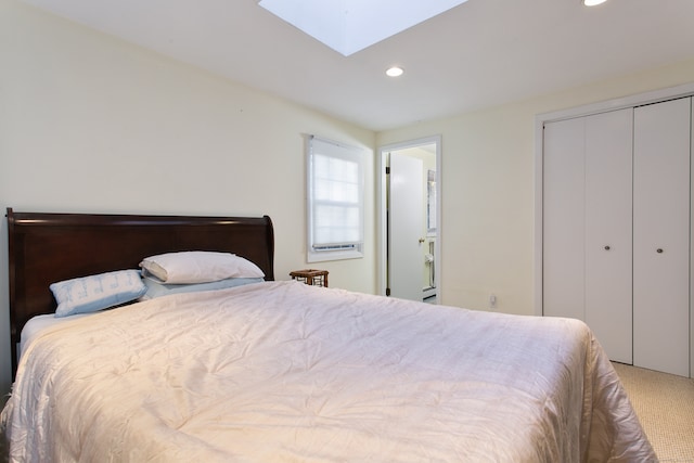 carpeted bedroom with a closet and a skylight