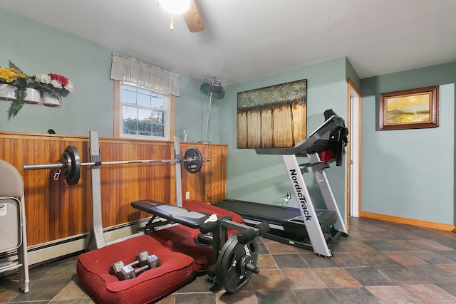 workout area with ceiling fan and a baseboard heating unit