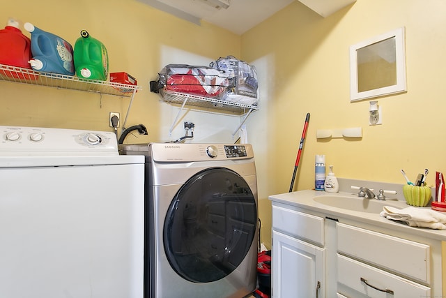 washroom with sink, washer and clothes dryer, and cabinets