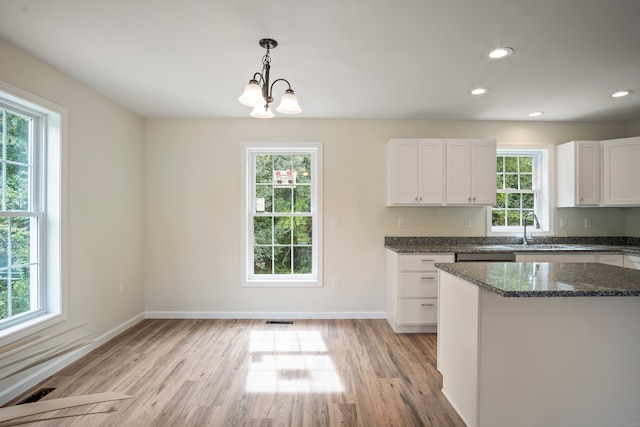 kitchen featuring white cabinets, a wealth of natural light, and light wood-type flooring