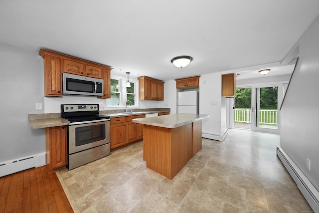 251 Stevens St, Bristol, CT 06010 - kitchen featuring appliances with stainless steel finishes, a baseboard heating unit, brown cabinets, light countertops, and a center island