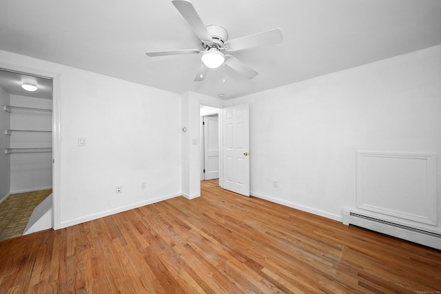 251 Stevens St, Bristol, CT 06010 - unfurnished bedroom with baseboard heating, a spacious closet, light wood finished floors, a ceiling fan, and a closet