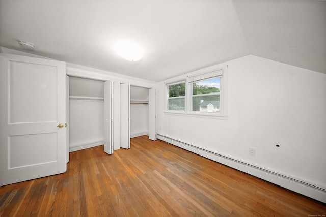 251 Stevens St, Bristol, CT 06010 - unfurnished bedroom featuring a baseboard heating unit, wood finished floors, lofted ceiling, and two closets