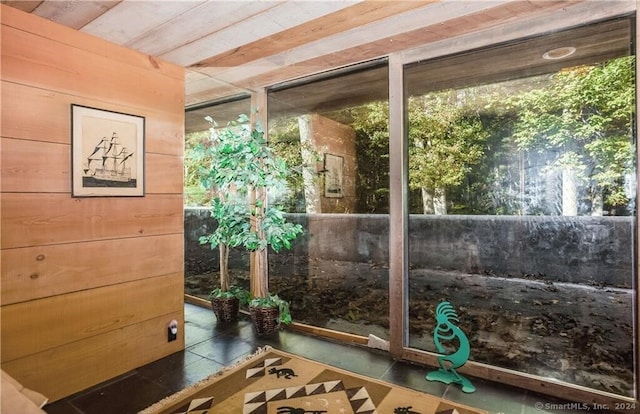 interior space with wood ceiling and dark tile patterned floors